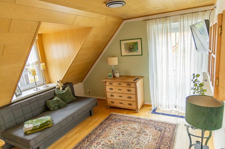 Wohnzimmer mit Sofa und Teppich in der Ferienwohnung Dorfzauber