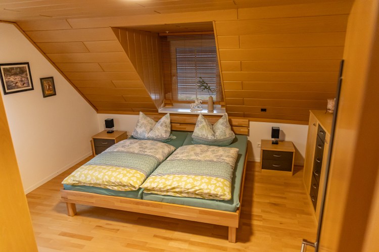 Schlafzimmer mit Holzbett und Nachttischlampe