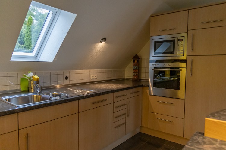 Küchenzeile mit Herd und Spüle in der Ferienwohnung Dorfzauber Neuburg