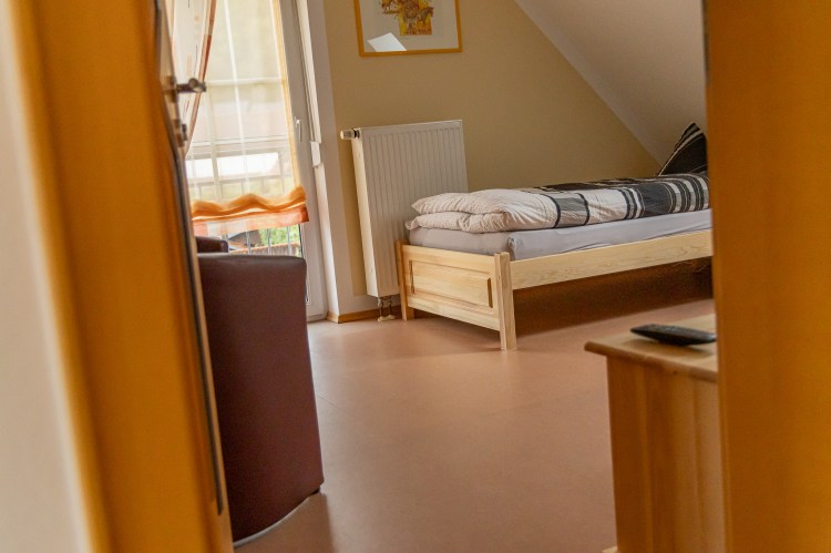 Schlafzimmer mit zwei Einzelbetten und Nachttischlampe großem Fenster