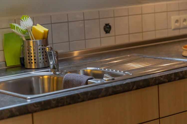 Spülbereich mit Edelstahlspüle und Fliesen